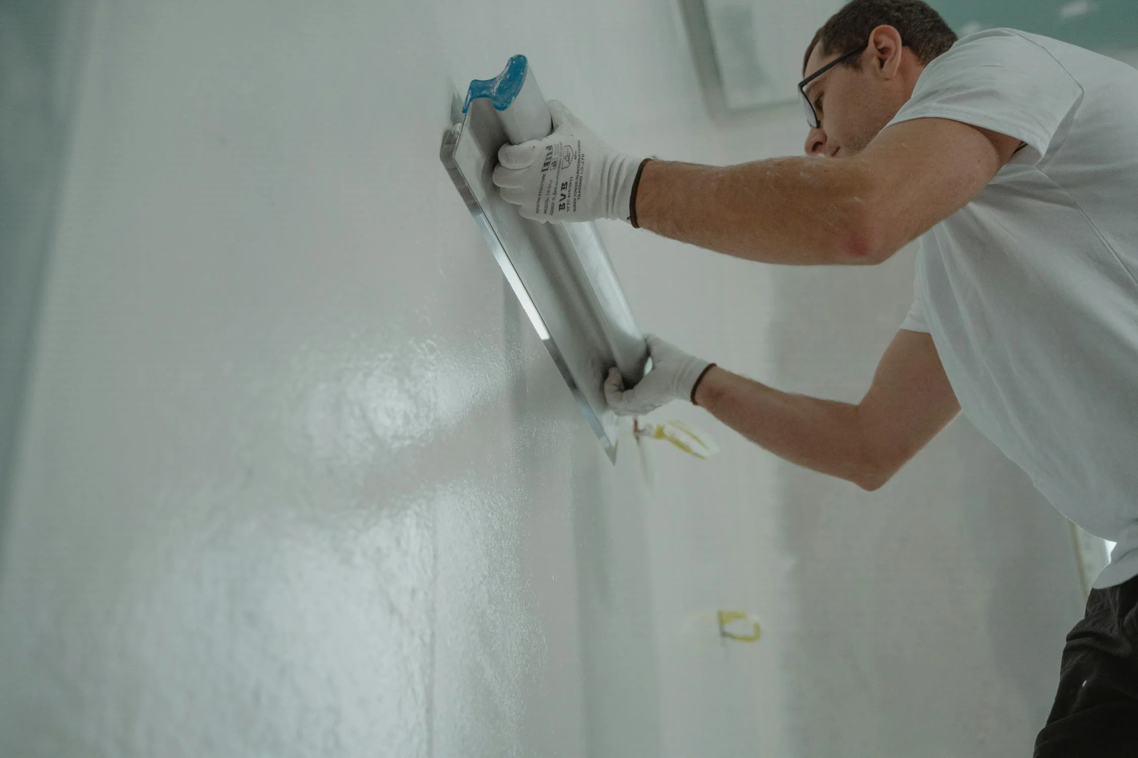 A head mason coating the plastering mix in the wall